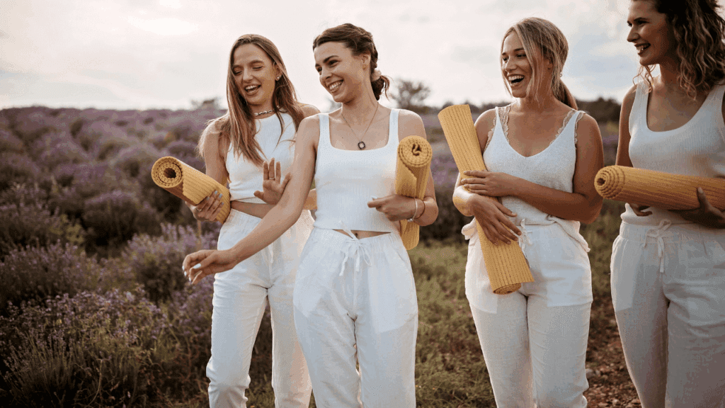 A group of four women in white outfits, each with a yoga mat, gather for a yoga session centered on life choices.
