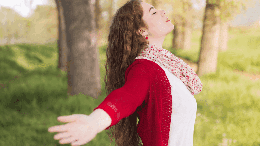 A woman joyfully stretches her arms upward, embodying the message "Healing Begins When You Redefine Success."