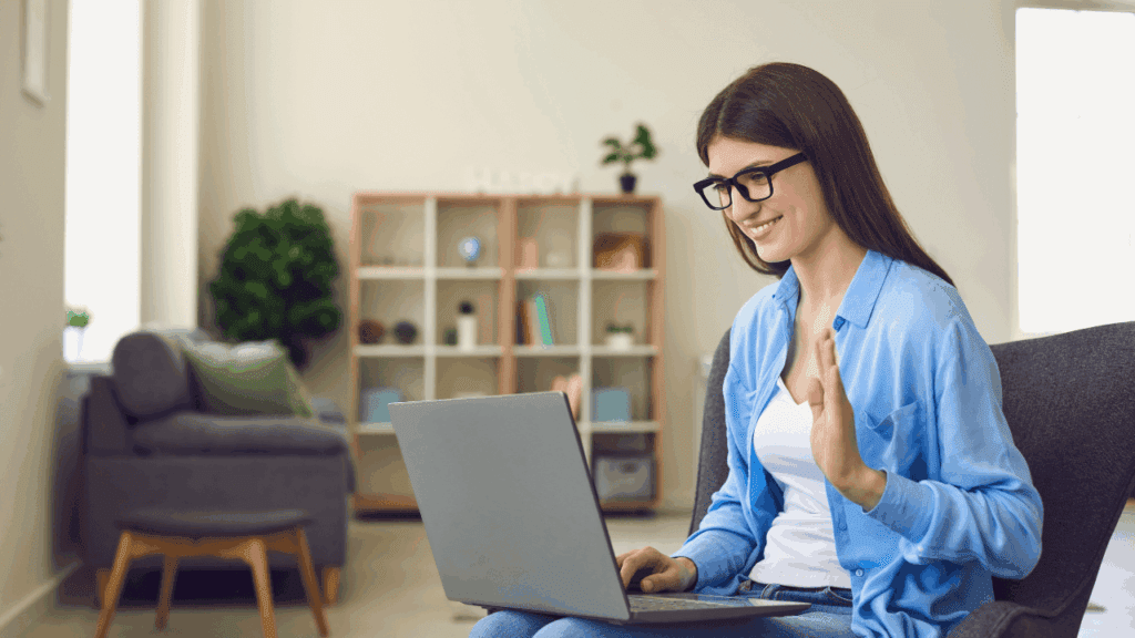  A woman at a desk with a laptop and pen, focused on business coaching versus executive coaching.